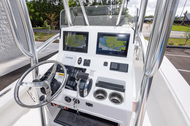 Slide: The Image of 2022 BlackJack 256 Coastal boat dashboard with dual navigation screens and steering wheel. - 23
