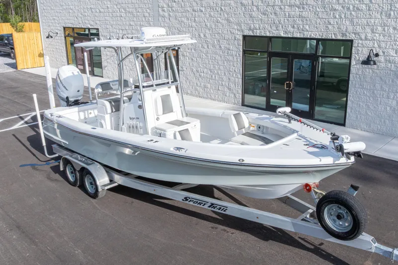 Slide: The Image of 2022 BlackJack 256 Coastal boat on trailer, parked outside a modern building. - 40