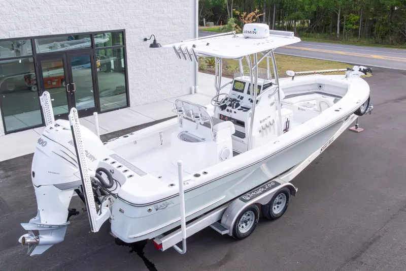 Slide: The Image of 2022 BlackJack 256 Coastal boat on trailer, parked near a building, featuring dual engines. - 42