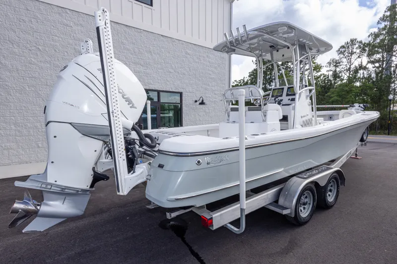 Slide: The Image of 2022 BlackJack 256 Coastal boat with Mercury engine on a trailer, parked outdoors. - 5