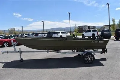 The Image of 2025 Lowe L1648M Jon boat on trailer in parking lot, clear sky background. - 0