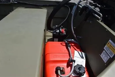 Slide: The Image of 2025 Lowe L1648M Jon boat interior with red fuel tank and battery setup. - 13
