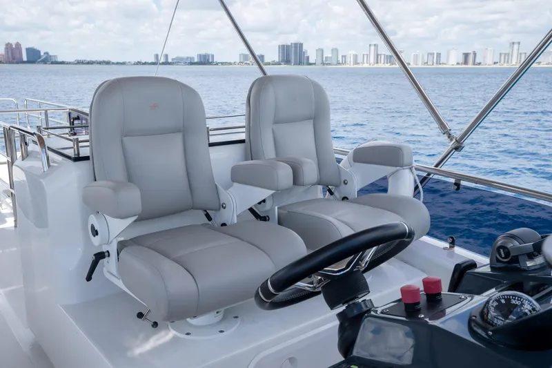 Slide: The Image of Luxury helm seats on 2025 Sirena 58 yacht, overlooking ocean and city skyline. - 18