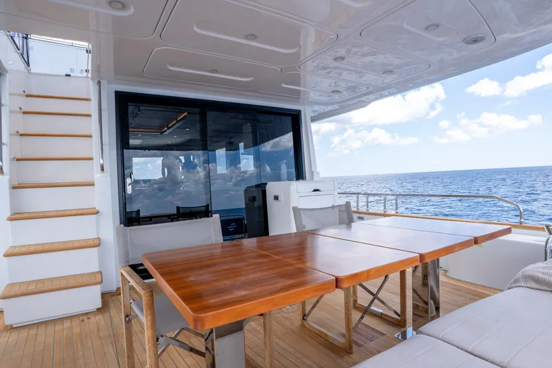 Slide: The Image of Luxurious Sirena 58 yacht deck with wooden table, ocean view, and modern design, 2025 model. - 22