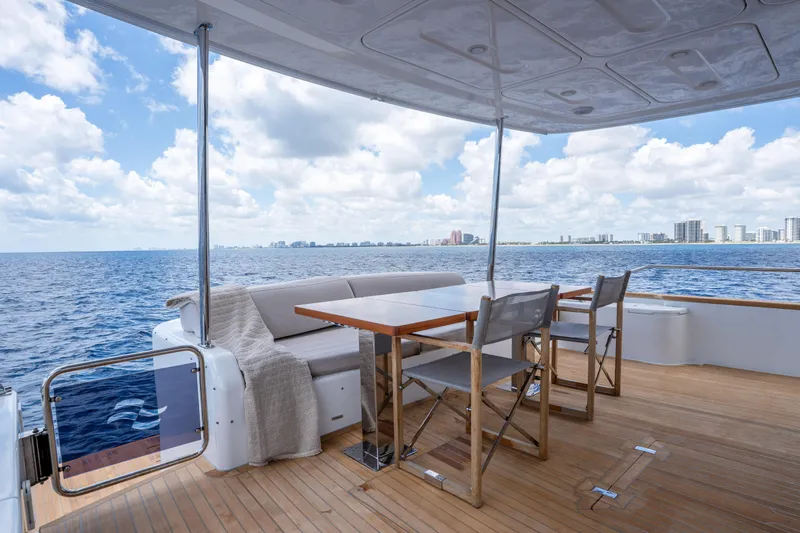 Slide: The Image of Luxurious Sirena 58 yacht deck with seating, ocean view, and city skyline, 2025 model. - 23