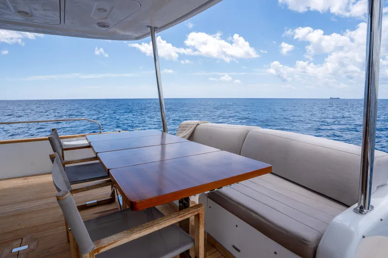 Slide: The Image of Luxury Sirena 58 yacht deck with elegant seating, ocean view, and clear blue sky, 2025 model. - 27