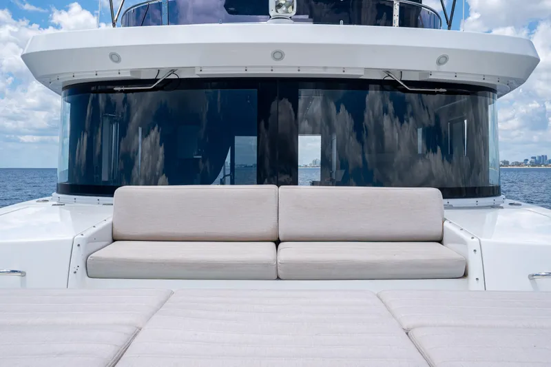 Slide: The Image of Luxurious Sirena 58 yacht deck with plush seating, reflecting ocean and sky, 2025 model. - 33