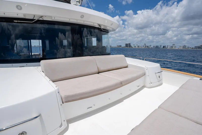 Slide: The Image of Luxurious Sirena 58 yacht deck with seating, ocean view, and city skyline, 2025 model. - 34