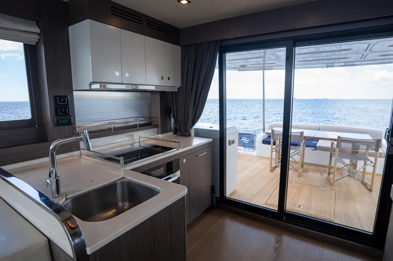 Slide: The Image of Modern kitchen on 2025 Sirena 58 yacht with ocean view through sliding glass doors. - 41