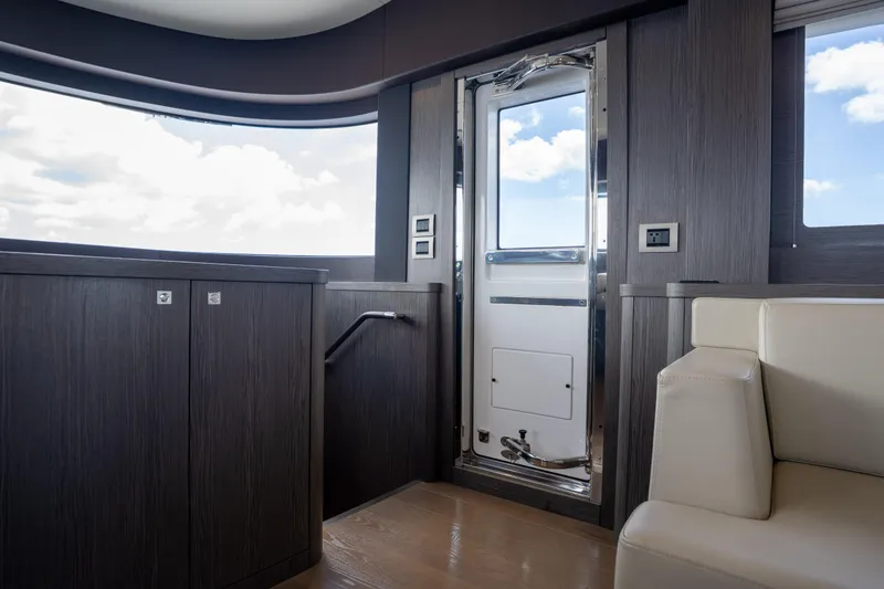 Slide: The Image of Interior of 2025 Sirena 58 yacht, featuring modern design with wood paneling and plush seating. - 55