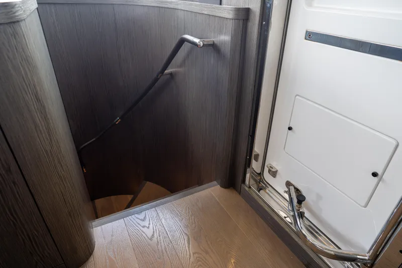 Slide: The Image of Staircase and door interior of 2025 Sirena 58 yacht, featuring sleek wood finish. - 56