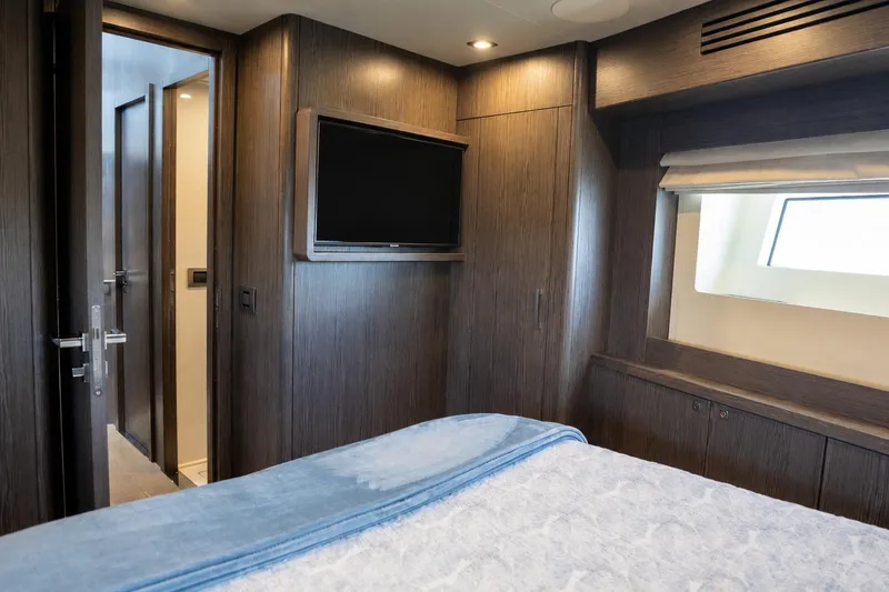 Slide: The Image of Luxurious cabin interior of 2025 Sirena 58 yacht with modern wood paneling and TV. - 69