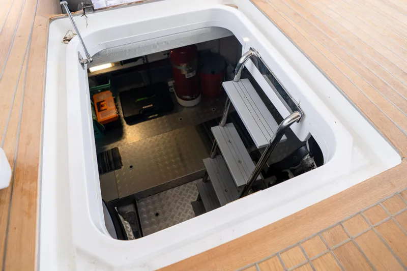 Slide: The Image of Engine room access hatch on 2025 Sirena 58 yacht, featuring metal steps and storage. - 75