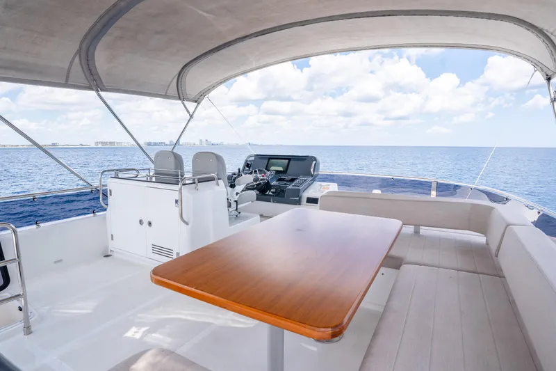 Slide: The Image of Flybridge of 2025 Sirena 58 yacht with seating, table, and ocean view. - 9
