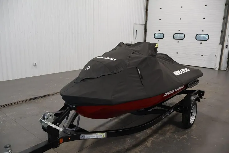 Slide: The Image of 2026 Sea-Doo RXP-X 325 jet ski covered on trailer in garage. - 13