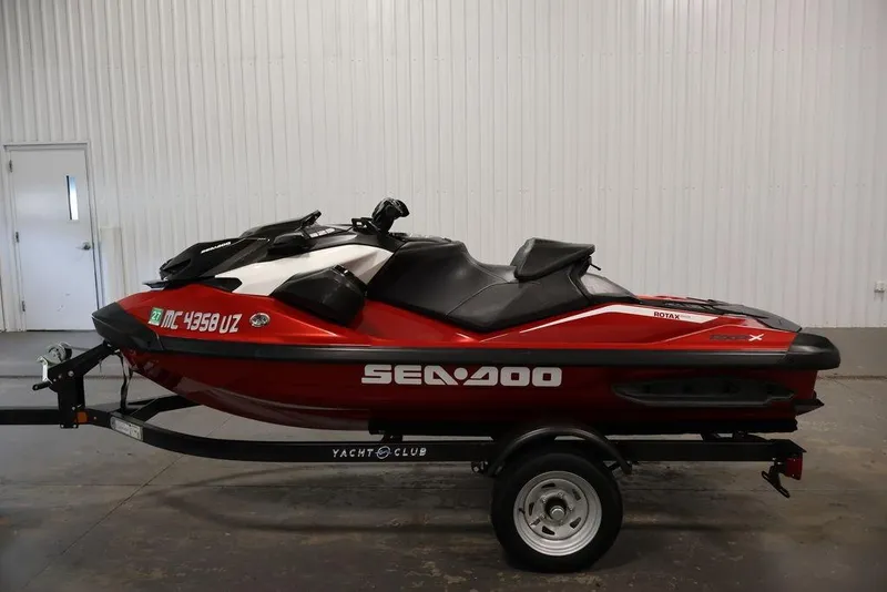 Slide: The Image of 2026 Sea-Doo RXP-X 325 jet ski in red, displayed on a trailer indoors. - 22