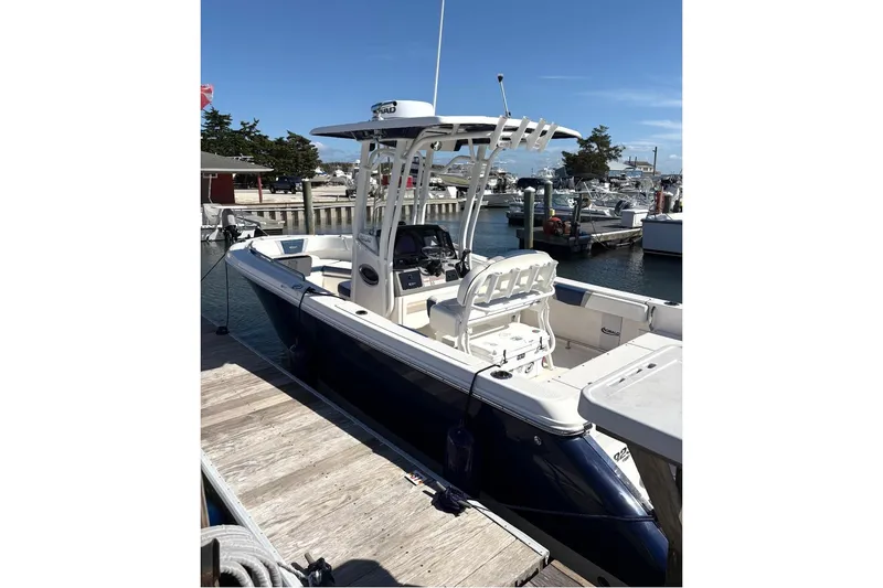 The Image of 2021 Robalo R230 Center Console boat docked at marina under clear blue sky. - 1