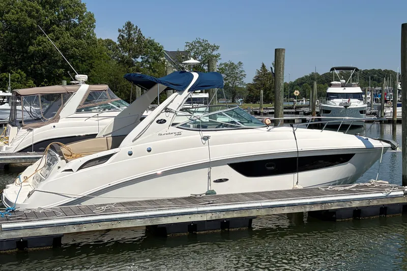The Image of 2015 Sea Ray 280 Sunrunner docked at marina, featuring sleek design and blue canopy. - 1