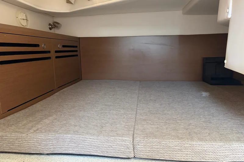 Slide: The Image of Interior cabin of 2015 Sea Ray 280 Sunrunner with cushioned seating and wooden cabinetry. - 10