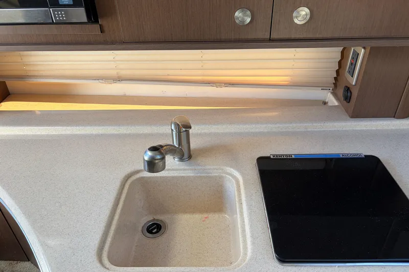 Slide: The Image of Interior kitchen area of a 2015 Sea Ray 280 Sunrunner boat with sink and stove. - 12