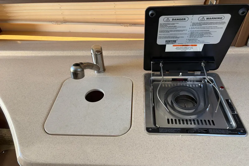 Slide: The Image of Kitchen area of 2015 Sea Ray 280 Sunrunner with sink and stove. - 13