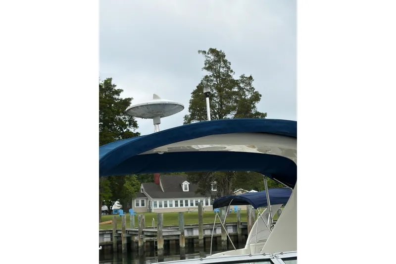 Slide: The Image of Sea Ray 280 Sunrunner 2015 boat docked near a waterfront house. - 15