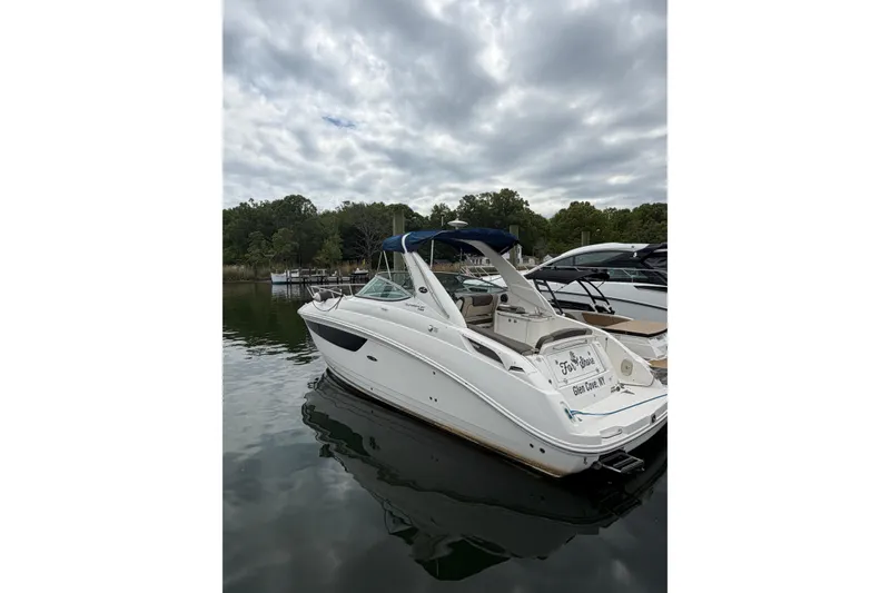 Slide: The Image of 2015 Sea Ray 280 Sunrunner boat docked on a calm lake under cloudy skies. - 3