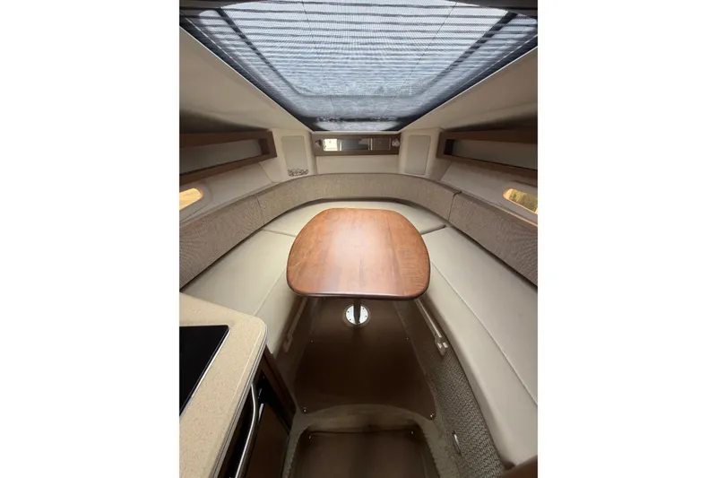 Slide: The Image of Interior cabin of 2015 Sea Ray 280 Sunrunner with wooden table and seating. - 9