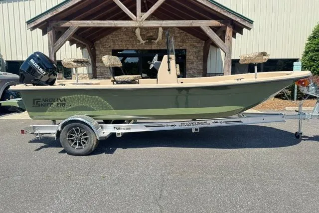 Slide: The Image of 2026 Carolina Skiff E18 JVX CC boat on trailer, parked outdoors. - 2