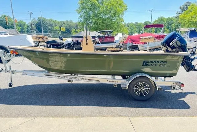 Slide: The Image of 2026 Carolina Skiff E18 JVX CC boat on trailer, parked outdoors. - 3