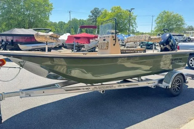 Slide: The Image of 2026 Carolina Skiff E18 JVX CC boat on trailer, parked outdoors. - 4