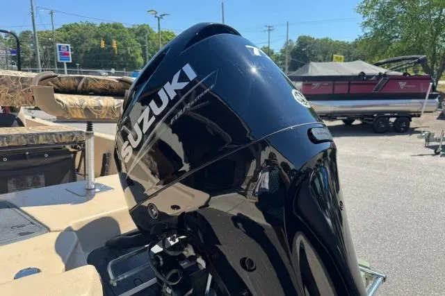 Slide: The Image of 2026 Carolina Skiff E18 JVX CC with Suzuki outboard motor in a sunny outdoor setting. - 5