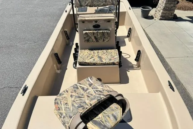 Slide: The Image of 2026 Carolina Skiff E18 JVX CC boat interior with camouflage seating and rod holders. - 7