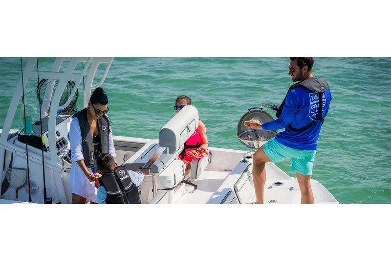 Slide: The Image of Family enjoying barbecue on Yamaha 195 FSH Sport boat, 2025 model. - 7