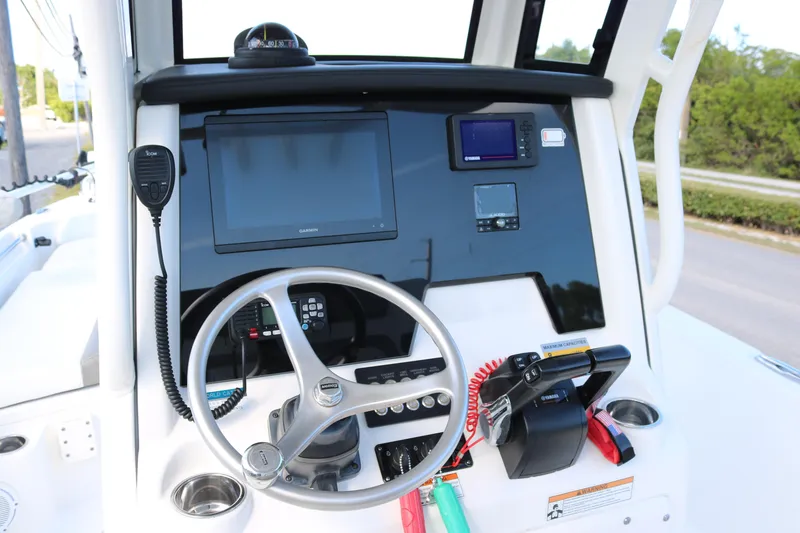 Slide: The Image of 2023 World Cat 235 CC boat dashboard with steering wheel and navigation equipment. - 13