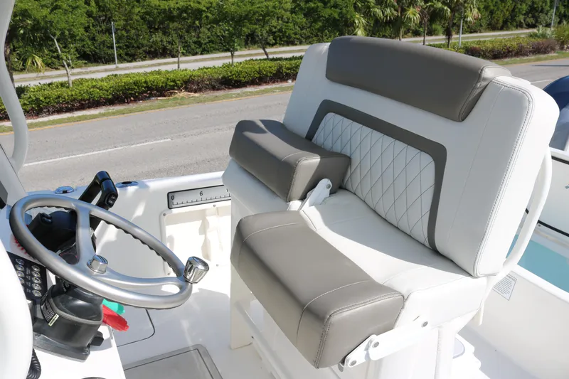 Slide: The Image of 2023 World Cat 235 CC boat interior with steering wheel and cushioned seating. - 14