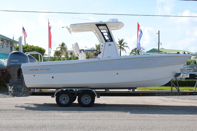 Slide: The Image of 2023 World Cat 235 CC boat on trailer with Yamaha engine, flags in background. - 3