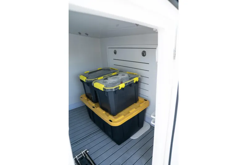 Slide: The Image of Storage area on 2025 Front Runner 43 Catamaran with stacked plastic bins. - 13