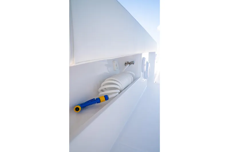Slide: The Image of Storage compartment with coiled hose on 2025 Front Runner 43 Catamaran. - 34