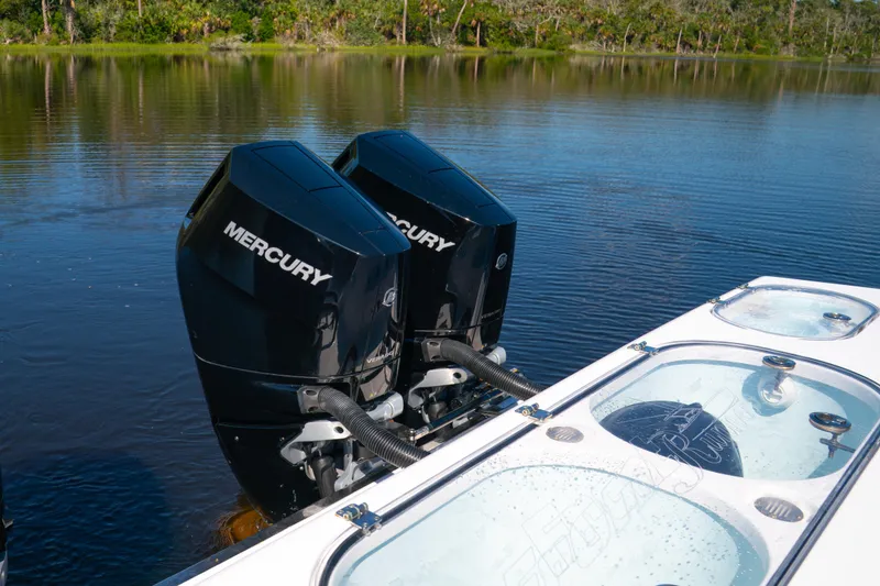 Slide: The Image of Twin Mercury outboard engines on a 2025 Front Runner 43 Catamaran, docked on a serene lake. - 62