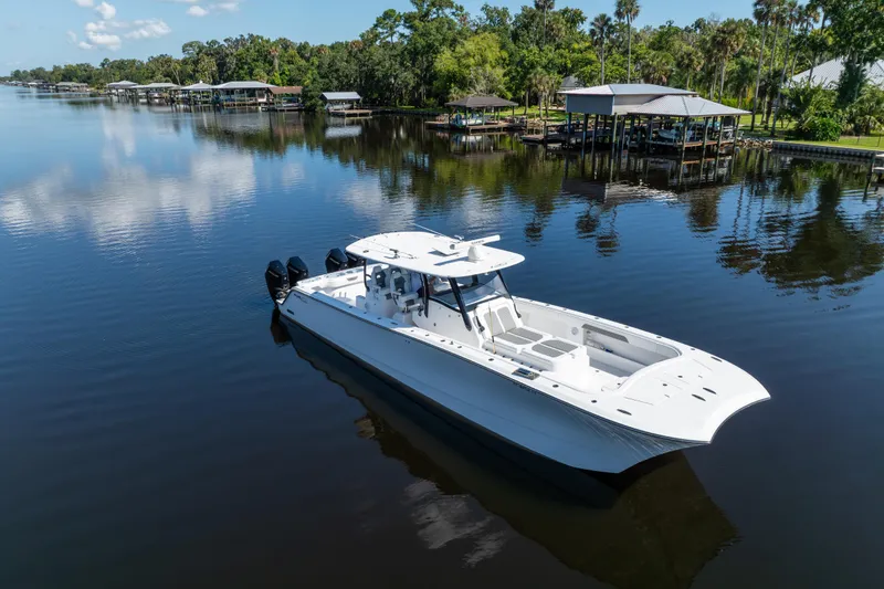 Slide: The Image of 2025 Front Runner 43 Catamaran on serene lake with lush greenery and docks. - 76