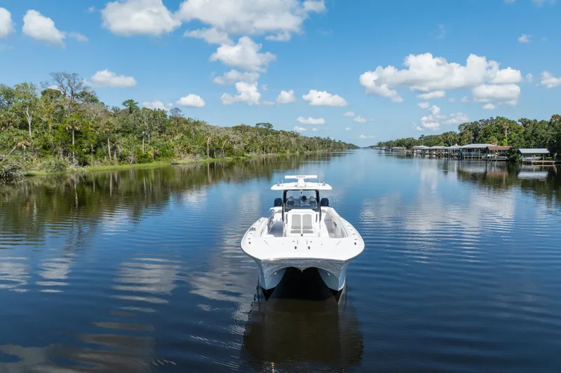 Slide: The Image of 2025 Front Runner 43 Catamaran cruising on a serene river under a blue sky. - 77