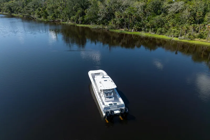 Slide: The Image of Front Runner 43 Catamaran 2025 cruising on a serene lake surrounded by lush greenery. - 79