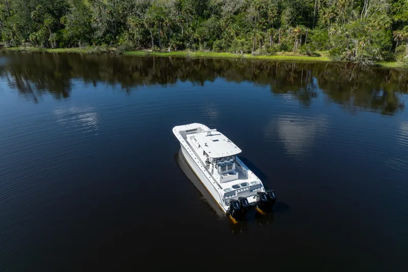 Slide: The Image of 2025 Front Runner 43 Catamaran on serene lake with lush forest backdrop. - 81