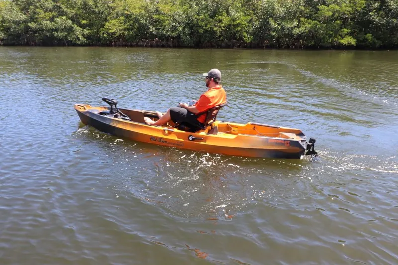 Slide: The Image of Man kayaking on a 2023 Old Town Sportsman Autopilot 136 in a calm river. - 21