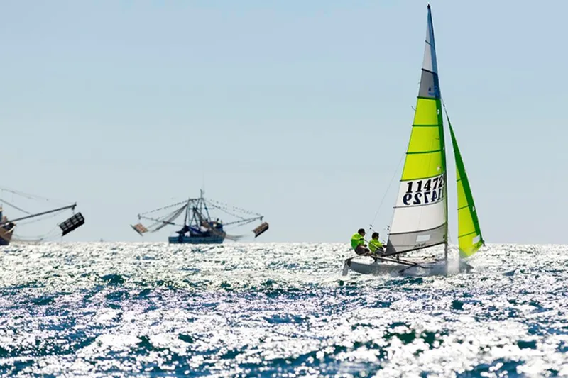 The Image of Sailors on a 2023 Hobie Cat H16 catamaran in sparkling ocean waters. - 1
