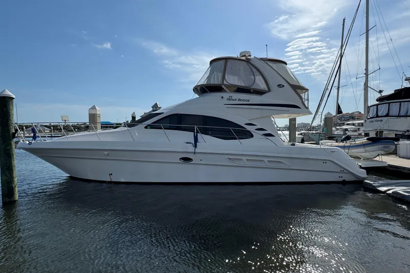The Image of 2006 Sea Ray 44 Sedan Bridge yacht docked at marina under clear sky. - 0