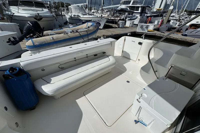 Slide: The Image of 2006 Sea Ray 44 Sedan Bridge yacht cockpit with seating and docked boats in background. - 8