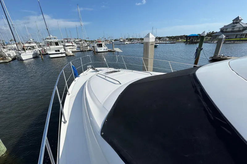 Slide: The Image of 2006 Sea Ray 44 Sedan Bridge yacht docked at a marina under clear blue skies. - 9