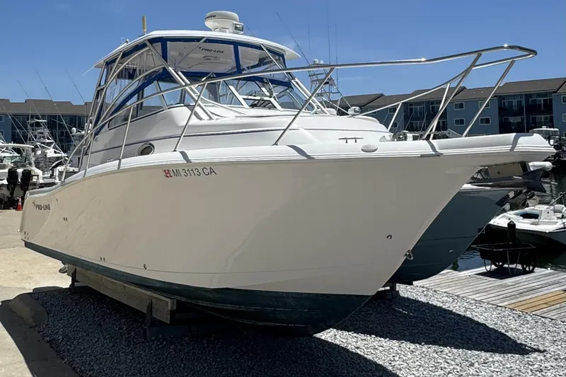 The Image of 2005 Pro-Line 32 Express boat docked at marina under clear blue sky. - 0